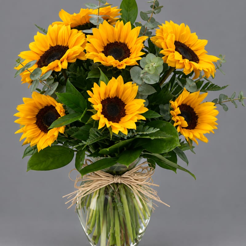 Bouquet of yellow sunflowers in a clear glass vase