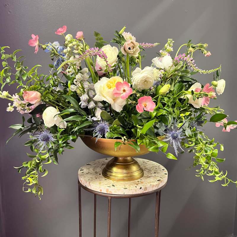 Large mixed floral arrangement in a gold pedestal bowl