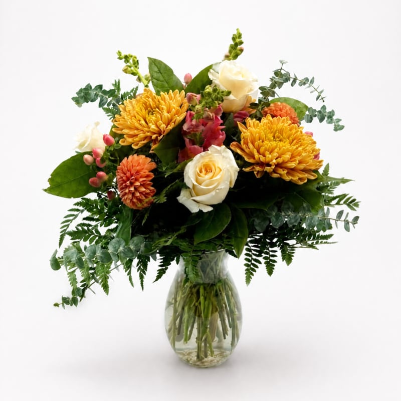 Bouquet of yellow and white flowers in a clear glass vase