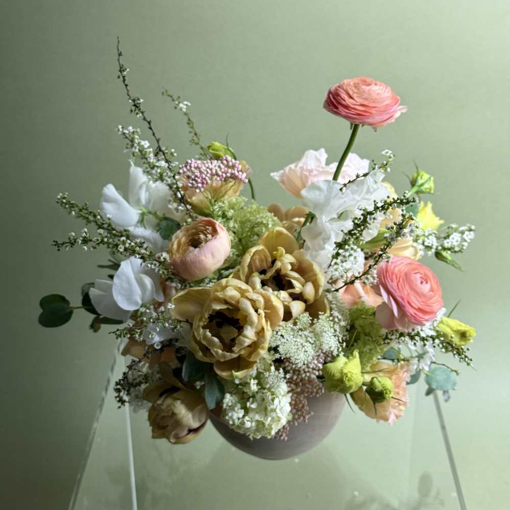 Mixed bouquet in a round vase with pink, white, and yellow blooms
