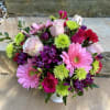 Mixed pink, purple, and green bouquet in a white vase