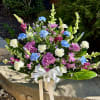 Colorful mixed bouquet in a silver vase with a white ribbon