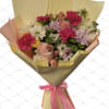 Bouquet of pink, white, and lavender flowers wrapped in gold paper with a pink ribbon