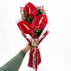 Bouquet of red anthuriums wrapped in patterned paper with a ribbon