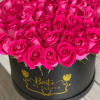 Hot pink roses arranged in a black round box