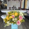 A vibrant blend of yellow sunflowers and ivory roses arranged in a