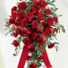 Standing spray of red roses and carnations with red ribbons on an easel