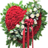 Standing red carnation heart spray with white roses and red ribbon on a greenery backing
