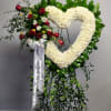 White carnations, white daisies, red roses and greenery.