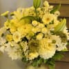 Yellow and white mixed flower arrangement in a glass vase
