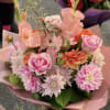 Pink and orange mixed bouquet with roses and daisies wrapped in pink paper