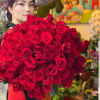 Woman holding a large bouquet of red roses
