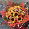 Bouquet of sunflowers and red roses wrapped in red paper