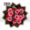 Pink gerbera daisies and red roses in a dark wrapped bouquet