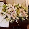 Large white and blush floral casket spray with orchids and roses
