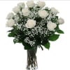 White roses and baby's breath in a clear glass vase