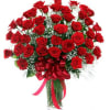 Bouquet of red roses in a glass vase with a red ribbon bow