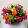 Colorful bouquet of roses, tulips, and orchids in a basket handle