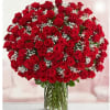 Large bouquet of red roses with baby's breath in a clear glass vase