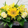 Yellow sunflower and white rose arrangement in a wicker basket