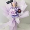 Lavender bouquet with a large rose and wrapped in pale purple paper