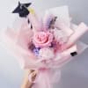 Pink rose bouquet with a graduation cap topper and pastel wrapping