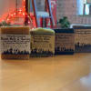 Four labeled bars of soap arranged on a wooden table