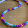 Colorful beaded necklace laid on a wooden surface