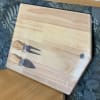 Wooden cutting board with a fork and knife attached