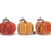 Three velvet pumpkins in orange and gold tones on a white background
