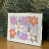 Floral greeting card with pink, orange, and white flowers on a lavender background