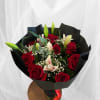 Bouquet of red roses and white lilies wrapped in black paper