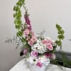 Pink roses and white hydrangeas in a white vase with tall green accents
