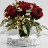 Red roses in a glass vase with small white filler flowers
