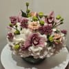 Pink orchids and white hydrangeas arranged in a dark vase
