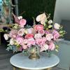 Pink and white floral arrangement in a gold pedestal vase