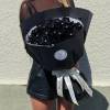 Large bouquet of black roses wrapped in black paper with a white ribbon