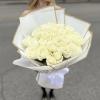 Bouquet of white roses wrapped in white paper with gold trim