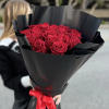 Bouquet of red roses wrapped in black paper with a red ribbon