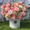 Large bouquet of pink and peach roses in a white box
