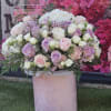 Large bouquet of pink, white, and lavender roses in a pink vase