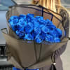 Bouquet of bright blue roses wrapped in brown paper