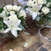 Pure white lilies and creamy roses clustered into low, rounded bouquets create