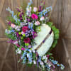 Heart-shaped funeral wreath with white flowers and pastel blooms