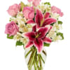 Pink roses and white lilies in a clear glass vase