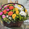 Basket of mixed roses and daisies in bright colors