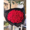 Large bouquet of red roses wrapped in black paper