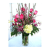 Pink roses and a pale yellow hydrangea in a clear glass vase