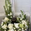 White floral arrangement with roses, snapdragons, and chrysanthemums in a silver container