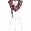 Heart-shaped pink rose wreath on a white easel with ribbon